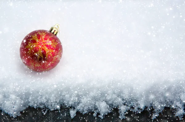 Rode Kerstbal geïsoleerd op witte sneeuw. — Stockfoto