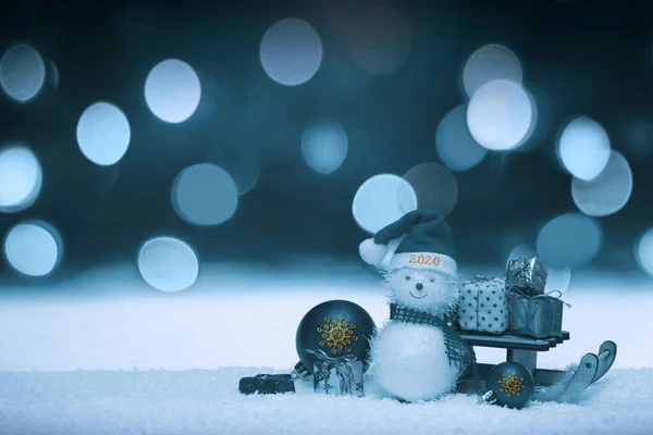 Nowy rok 2020. Bałwan z kapeluszem Świętego Mikołaja na śniegu . — Zdjęcie stockowe