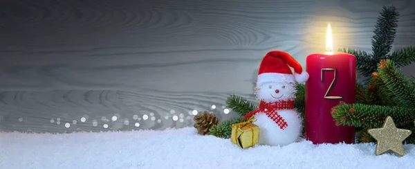 Fundo de Natal com segunda vela do Advento e boneco de neve com decoração vermelha . — Fotografia de Stock