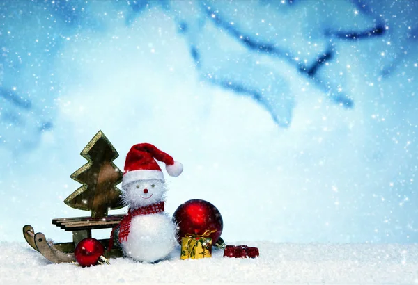 Schneemann mit Weihnachtsgeschenken auf dem Schlitten . — Stockfoto