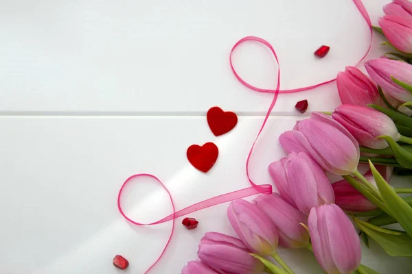 Tulipanes rosados y dos corazones de amor aislados sobre madera blanca Fondo. — Foto de Stock