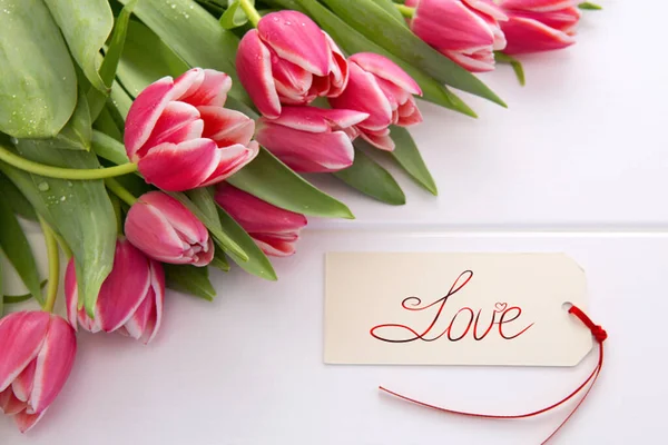 Karta Vlentines Day i bukiet pięknych tulipanów na drewnianym tle. — Zdjęcie stockowe