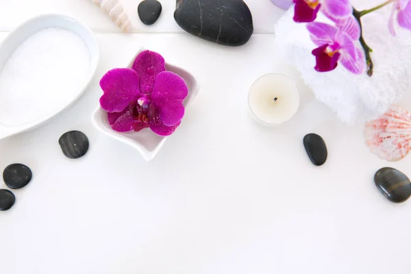 Ajuste de spa con orquídeas rosadas, piedras negras y sales de baño sobre fondo de madera. — Foto de Stock