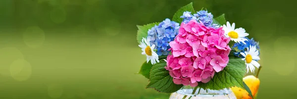 Ramo de flores de colores en jarrón de vidrio aislado en verde . — Foto de Stock