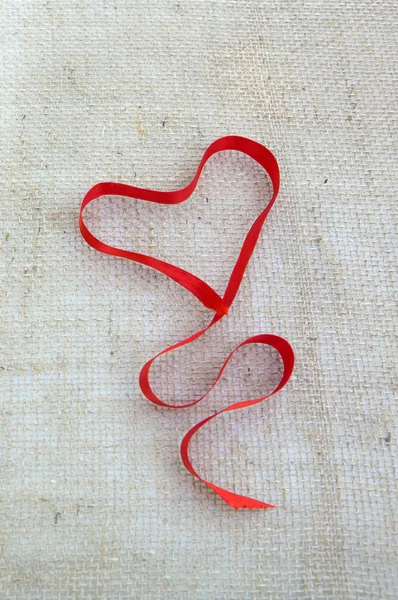 Červená srdeční stuha izolované na šedém plátně pozadí. — Stock fotografie