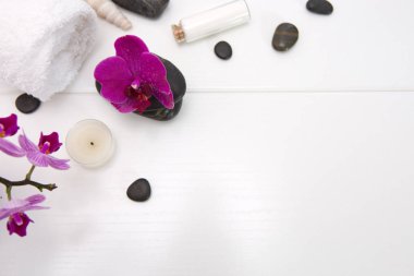 Pembe orkideli spa seti, siyah taşlar ve beyaz üzerine banyo tuzu. .