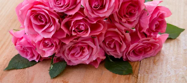 Ροζ τριαντάφυλλο μπουκέτο απομονώνονται σε ξύλινο φόντο. — Φωτογραφία Αρχείου