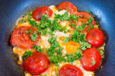 Tavada yumurta, domates ve tavada maydanoz..