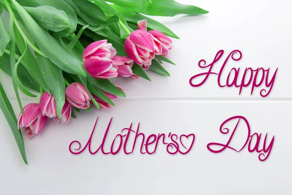 Cartão de Dia das Mães e um buquê de belas tulipas em fundo de madeira . — Fotografia de Stock