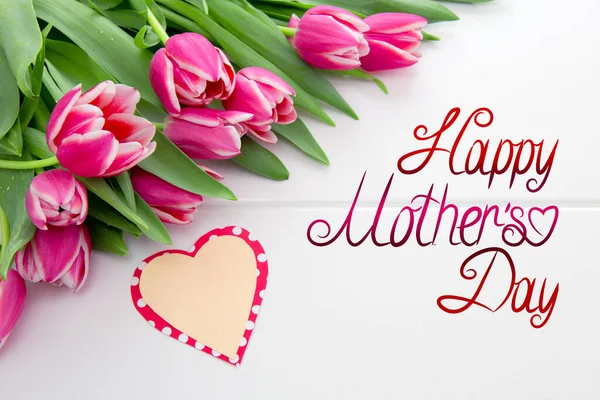 Mothers Day card and a bouquet of beautiful tulips on wooden background.