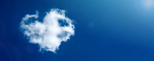 Сердце в форме облака на голубом весеннем небе . — стоковое фото