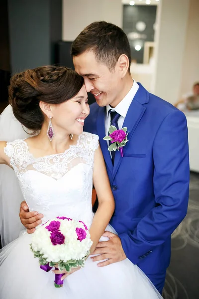 Charmantes Paar Braut und Bräutigam in der Lobby lachend und echt lächelnd positives Porträt. aufrichtige Gefühle, starke Emotionen. Brautstrauß in Händen, alles in einer Farbe. — Stockfoto