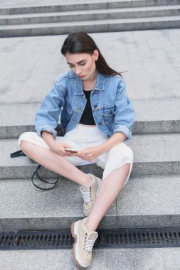 genç kadın tasarımcı manifatura onun smartphone açık havada üzerinde