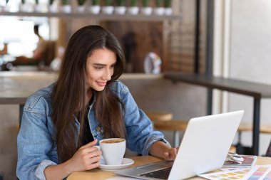 bir kafede oturan kadın blogger