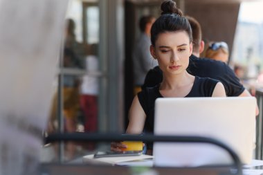 satisfied female freelancer sitting in front of a laptop clipart