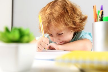 Kızıl saçlı çocuk evde oturan gülümseyen