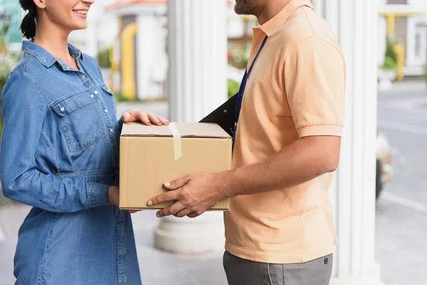 Courier making delivery to beautiful woman — Stock Photo, Image