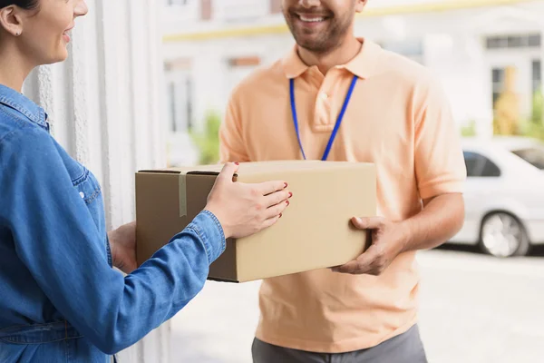 Mensageiro fazendo entrega para mulher bonita — Fotografia de Stock