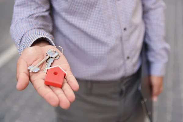 Smiling man holding up keys — Stock Photo, Image