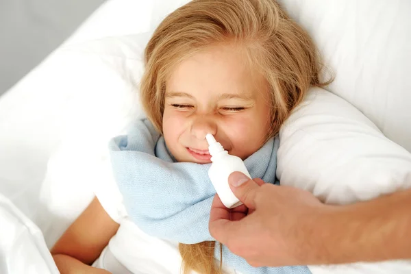 Mano con spray nasale vicino a bambino malato — Foto Stock