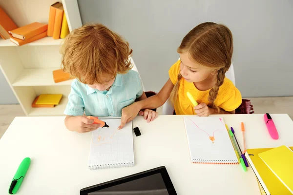 Niños inteligentes dibujando en el cuaderno en interiores — Foto de Stock