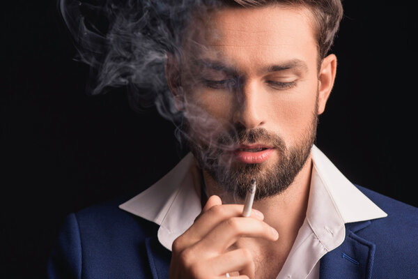 Attractive businessman enjoying cigar smoke