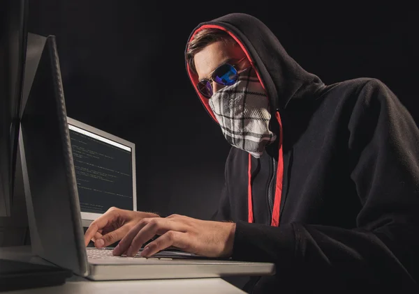 Young thief searching in laptop — Stock Photo, Image