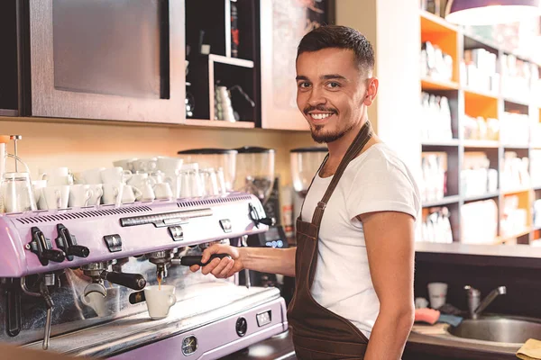 Веселый парень, который работает на кухне, улыбается — стоковое фото