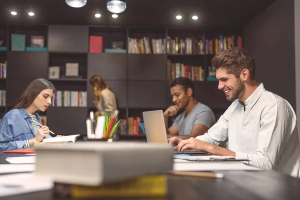 Estudiantes haciendo proyecto de grupo en la biblioteca del campus — Foto de Stock