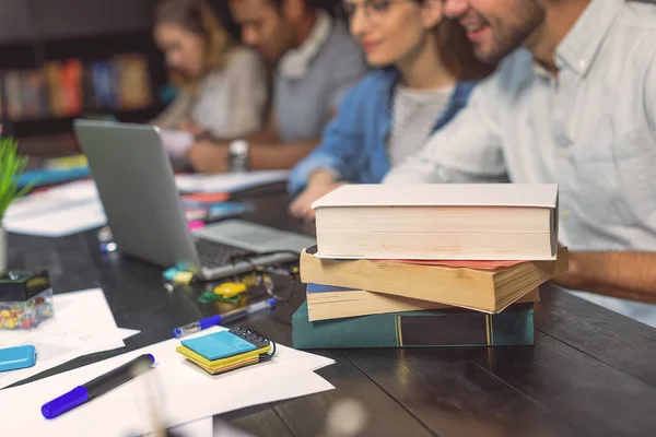 Estudiantes universitarios sentados juntos y estudiando — Foto de Stock