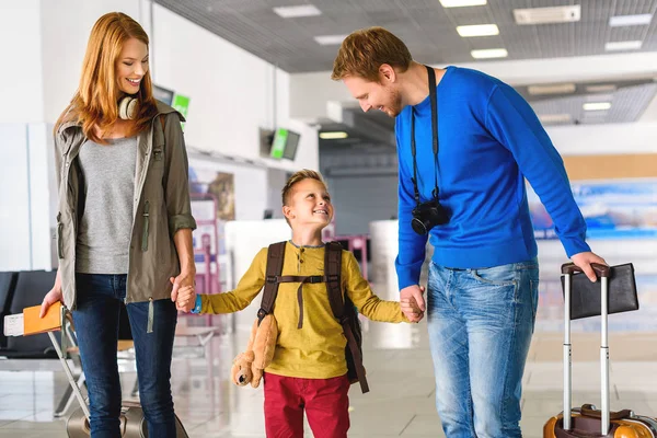 Щаслива сім'я з валізами в аеропорту — стокове фото