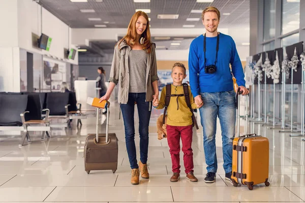 Lycklig familj med resväskor i flygplats — Stockfoto