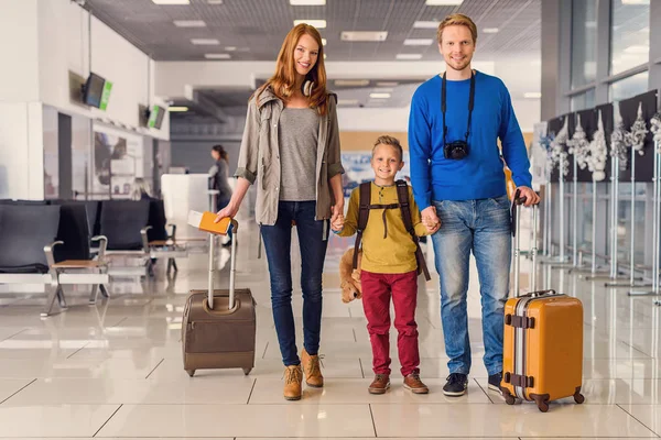 Família feliz com malas no aeroporto — Fotografia de Stock