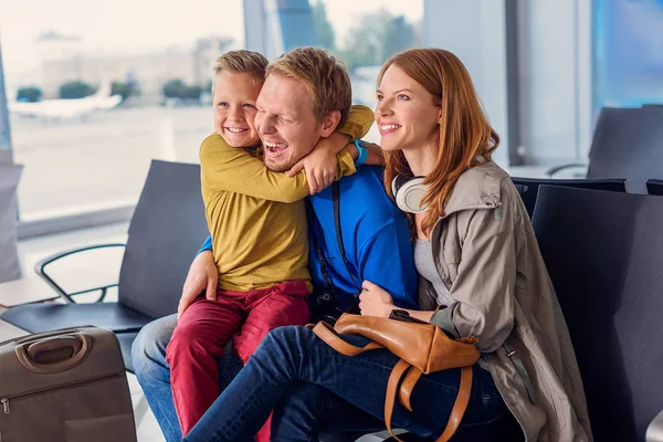 Щаслива сім'я обіймається в аеропорту — стокове фото