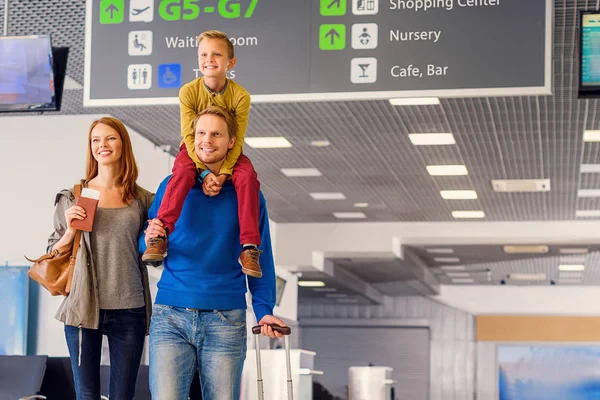 Щаслива сім'я з валізою в аеропорту — стокове фото