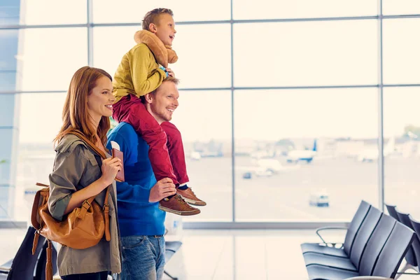 Família feliz com mala no aeroporto — Fotografia de Stock
