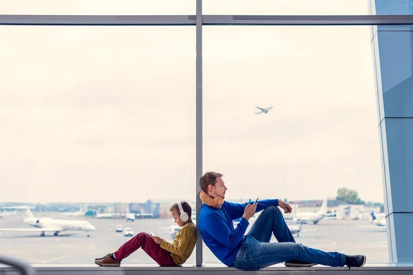 Pai e filho esperando para embarcar no aeroporto — Fotografia de Stock