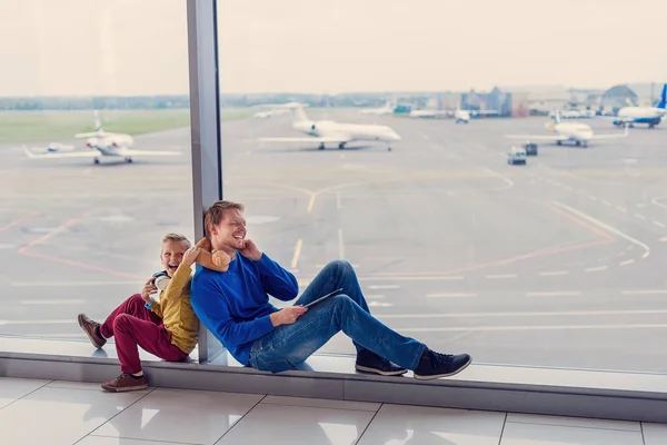 Pai e filho esperando para embarcar no aeroporto — Fotografia de Stock