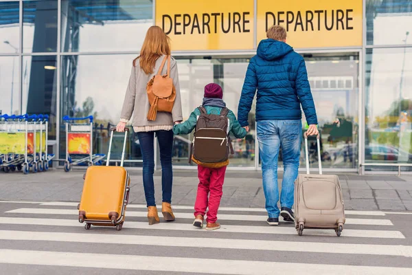 Улыбающаяся семья с ребенком в аэропорту — стоковое фото