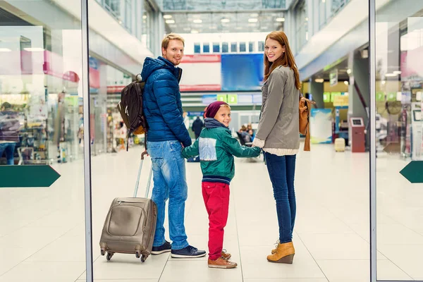 Famiglia sorridente con bambino in aeroporto — Foto Stock