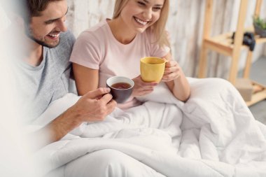 Mutlu aşıklar yatak odasında sıcak içecek keyfi