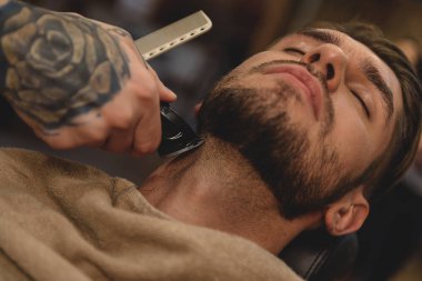 Elektrikli jiletle tıraş olmak.