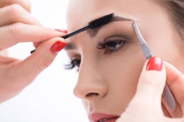 Genç kadın güzellik salon kaşlarını tweezing
