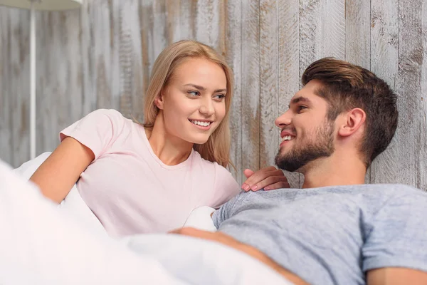 Gelukkig man en vrouw liggend in slaapkamer — Stockfoto