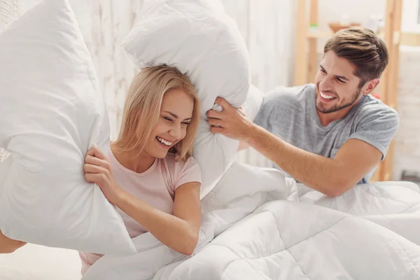 Беззаботная любящая пара веселится с подушками — стоковое фото