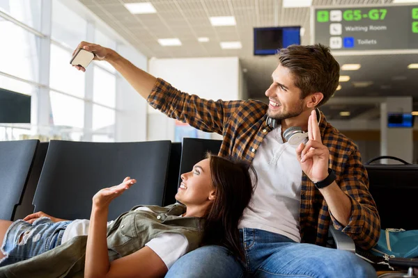 Hombre y mujer gozosos fotografiando durante el viaje — Foto de Stock