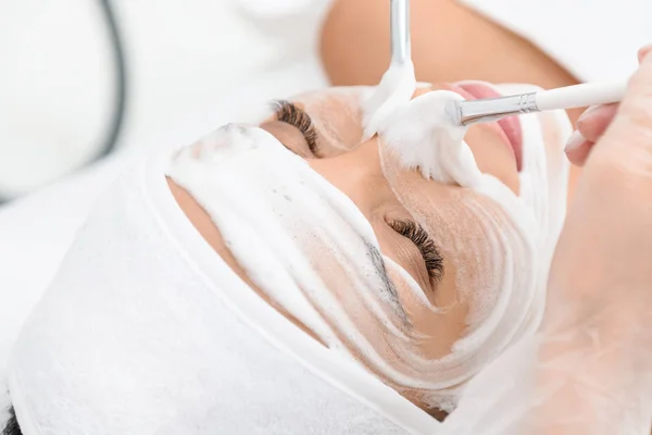 Menina bonita recebendo procedimento de espuma facial no spa — Fotografia de Stock