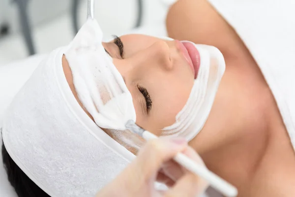 Mujer joven y saludable recibiendo tratamiento facial en el spa — Foto de Stock