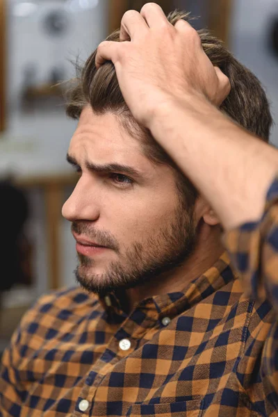 Close up homem tocando seu cabelo dentro de casa — Fotografia de Stock