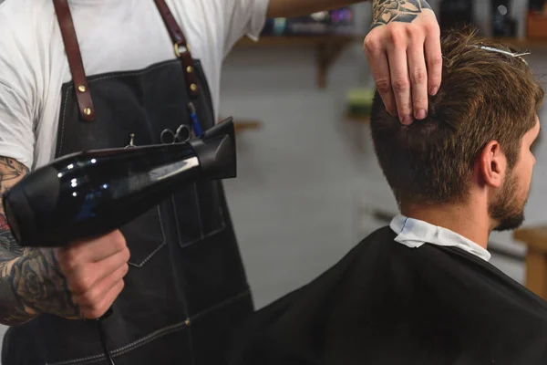 Foco seletivo no cabelo de secagem estilista do cliente — Fotografia de Stock